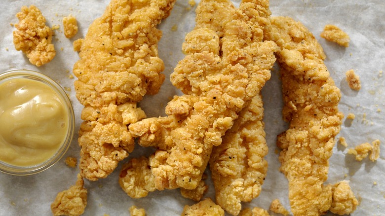 hand battered chicken tenders next to ramekin of honey mustard