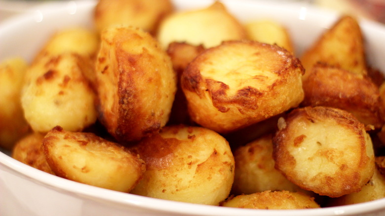 White bowl with golden roasted potatoes