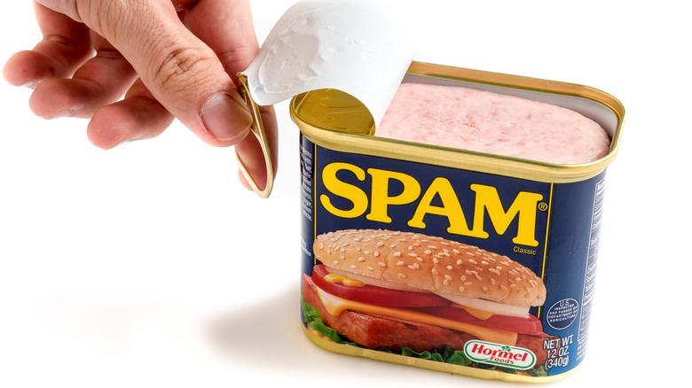 hand opening Spam can