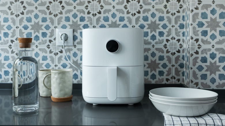 Air fryer next to bottle of liquid