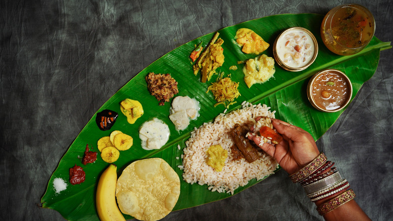 A woman eating South Indian food with her hand