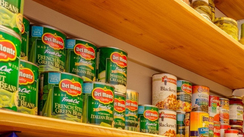 Cans of vegetables lining a shelf