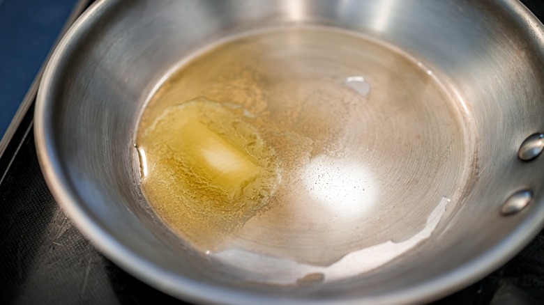 Butter melting in a stainless steel pan 