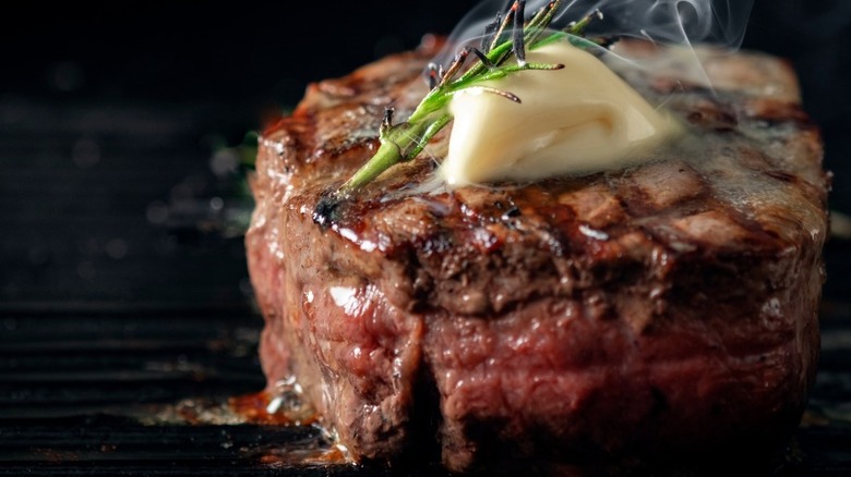 Grilled steak with butter and rosemary