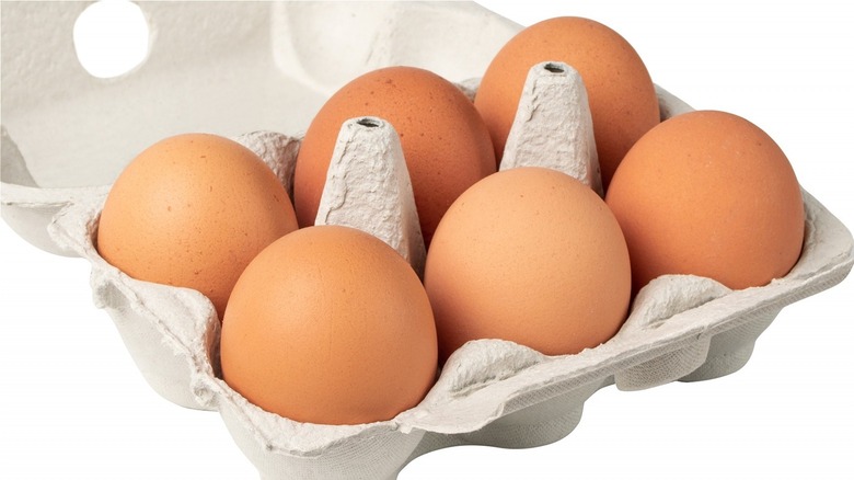 Half dozen brown eggs in carton