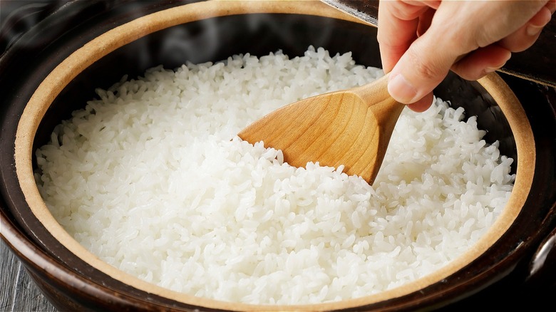 hand scooping white rice
