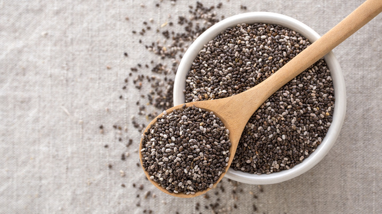 Chia seeds in bowl with wooden spoon
