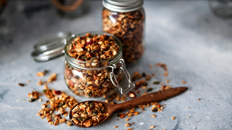two jars of granola and wooden spoon