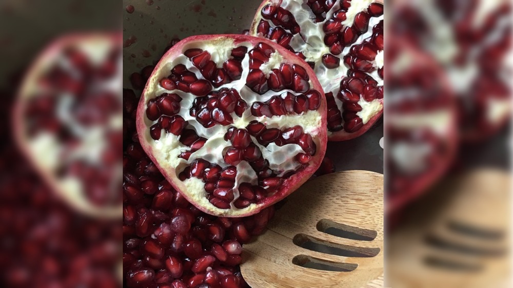 Pomegranate seeds with wooden spoon