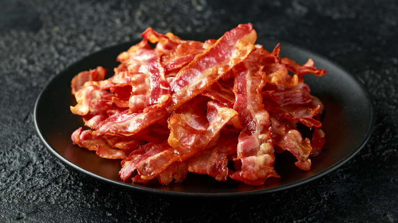 Plate of bacon on dark table