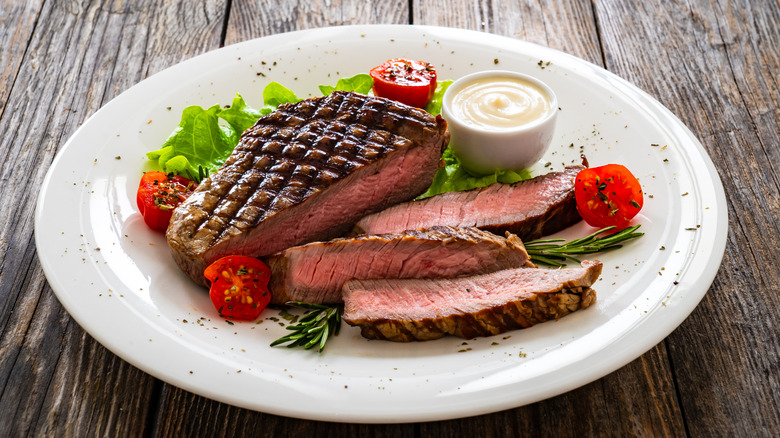 Grilled steak sliced on white plate