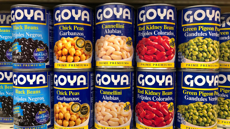 Variety of Goya brand canned beans on store shelf