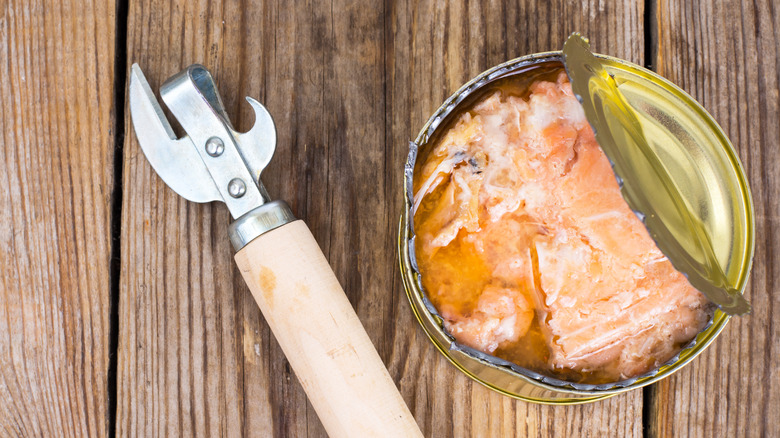 Partially opened can of salmon with opener