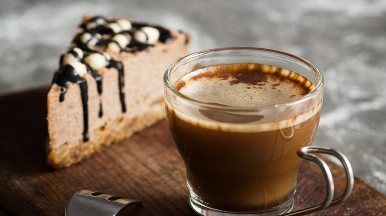 Chocolate mousse cake and glass mug of coffee on wood block