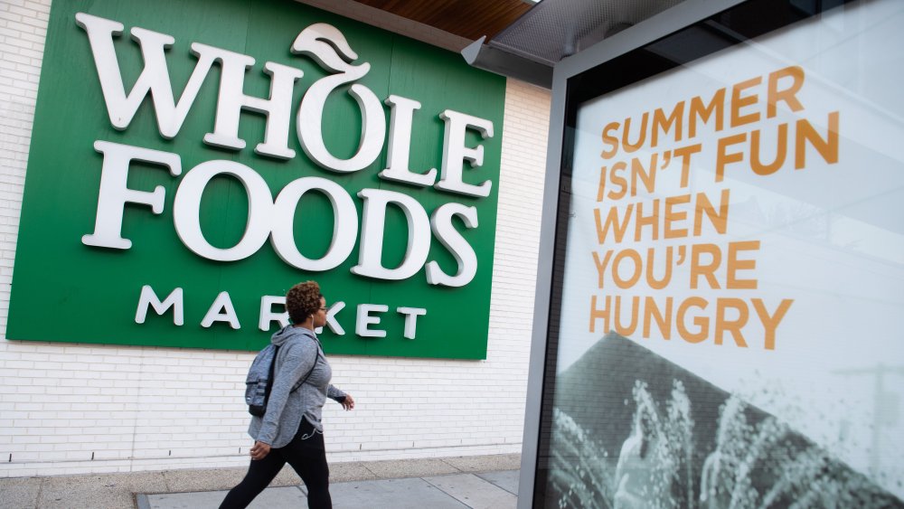 A woman walks past a Whole Foods