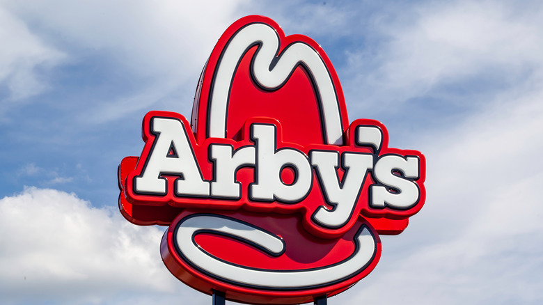 Red and white Arby's logo against blue sky