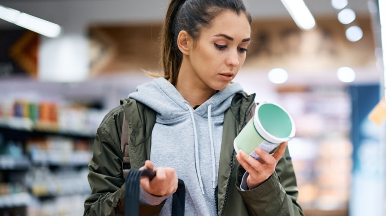 Woman reading food packaging in store