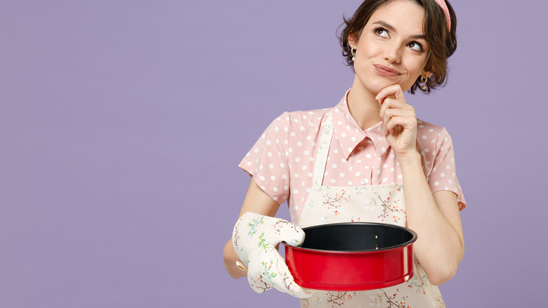 woman baker holding metal pan