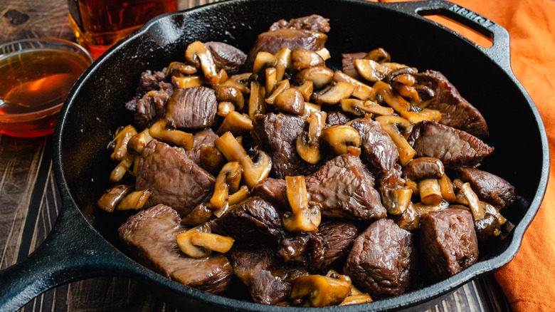 Cast iron pan with steak tips and mushrooms