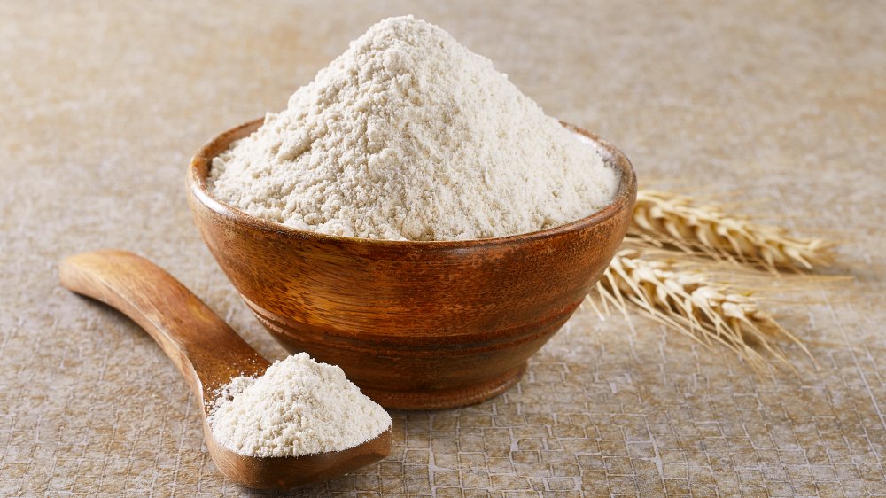 Bowl of flour with spoon filled with flour