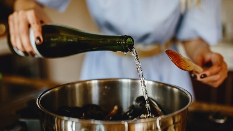female chef pouring wine into a pot