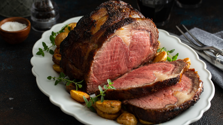 A classic prime rib roast sliced on a platter.
