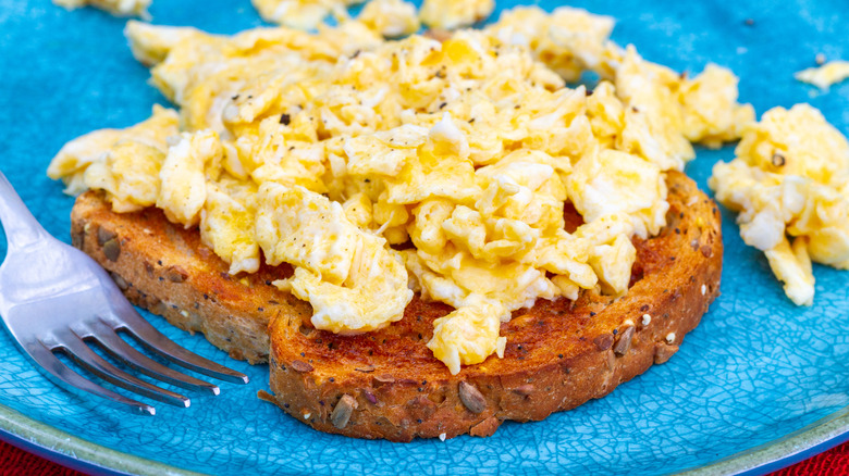 Scrambled eggs on toast on a blue plate