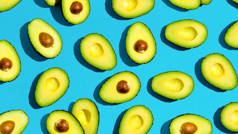 Avocados sliced open revealing avocado pit