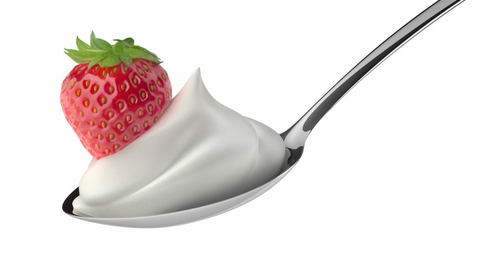 Cool whip whipped topping on a spoon with a strawberry