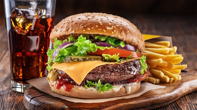 A burger with fries and soda