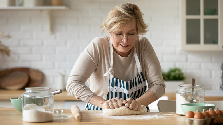 Woman in the kitchen kneading dough