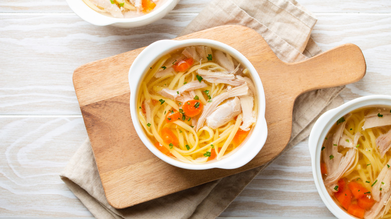 Homemade chicken soup on cutting board