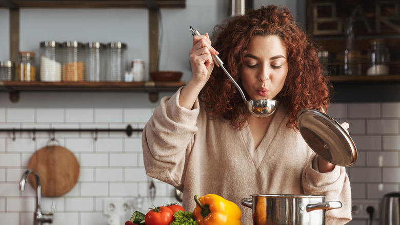 Woman tasting soup from ladel