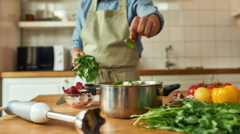 Man putting herbs in pot