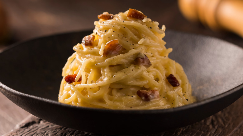 Traditional spaghetti alla carbonara in black bowl