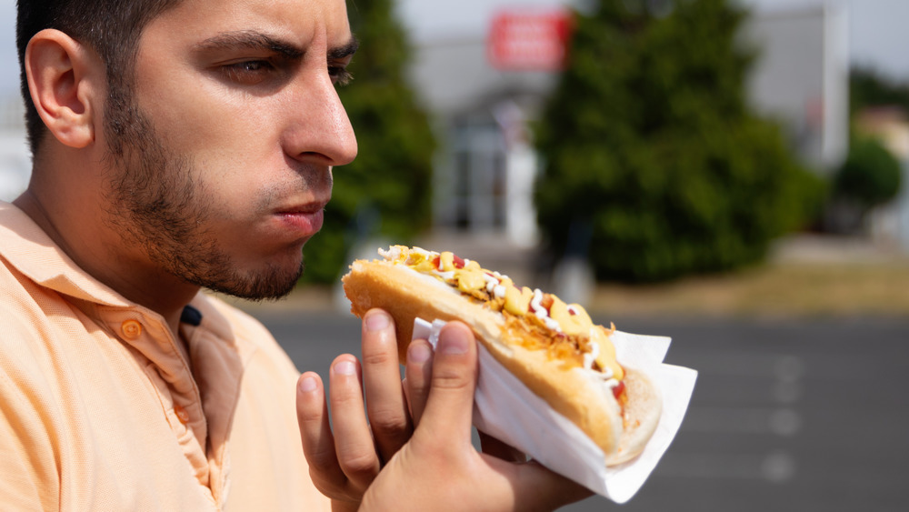  A man eating a hot dog 
