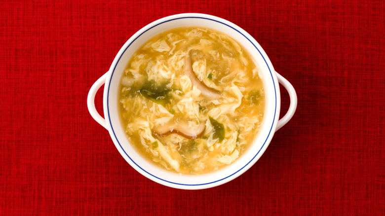 egg drop soup against red background