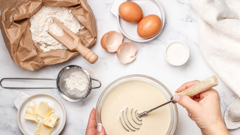 Ingredients for baking cupcakes spread across a marble surface