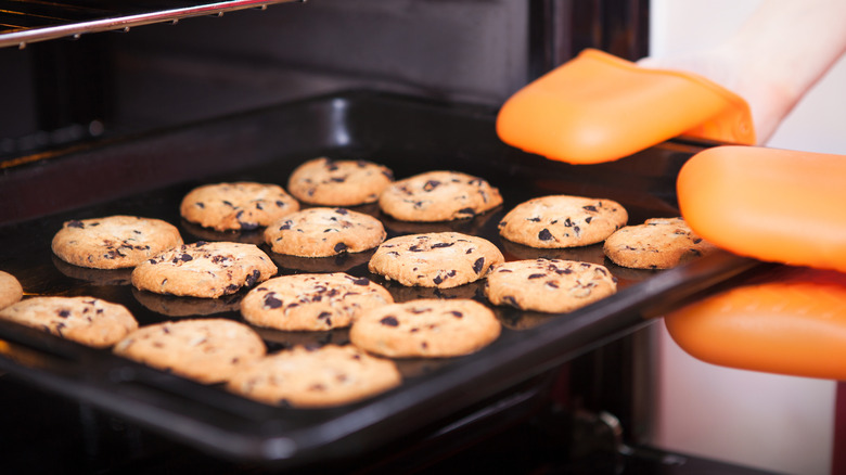 pulling cookies from oven
