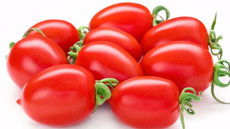 Nine fresh San Marzano tomatoes against white background