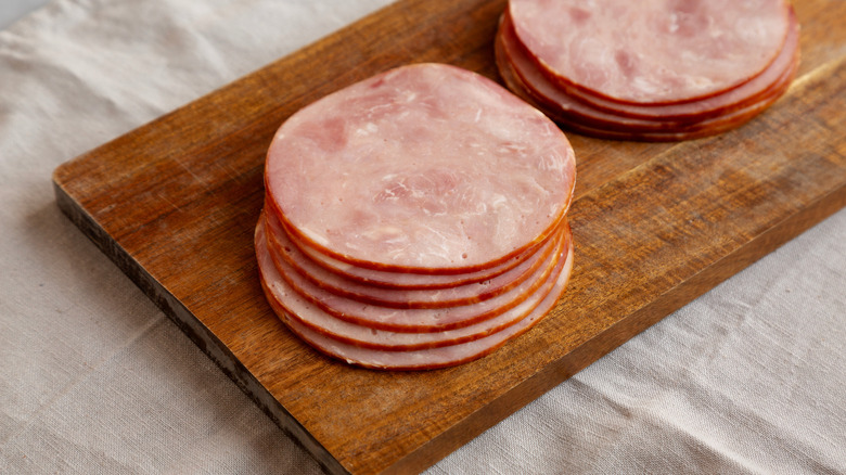Slices of cold cut ham on wooden board