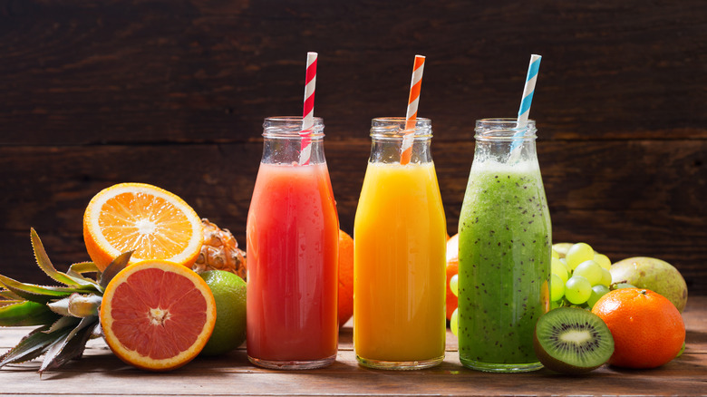 Three bottles of fruit juice with straws