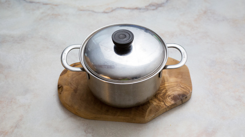 covered pot on cutting board