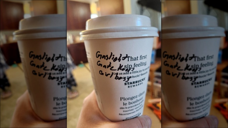 Starbucks cup with "Gaslight Gatekeep Girlboss" written in black marker.