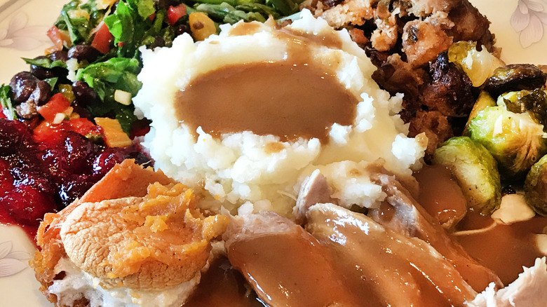 Thanksgiving plate with turkey, mashed potatoes and gravy, vegetables and cranberry sauce