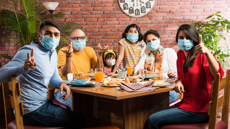 Family of diners wearing face masks