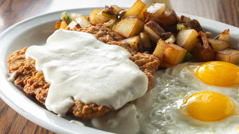 country fried steak and gravy with eggs and potatoes