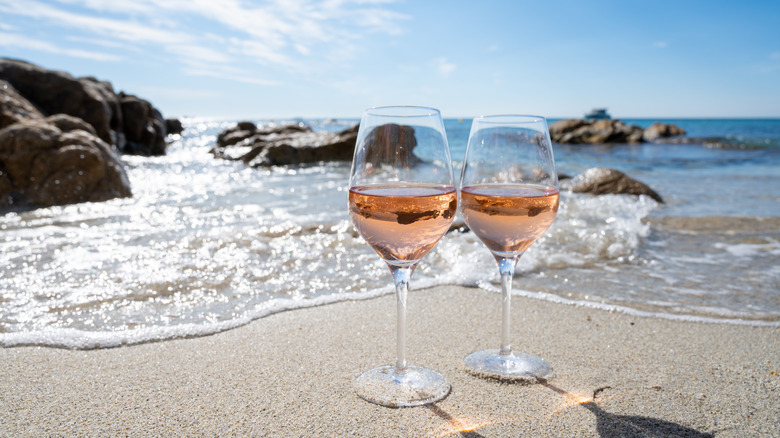 Rose wine glasses on beach