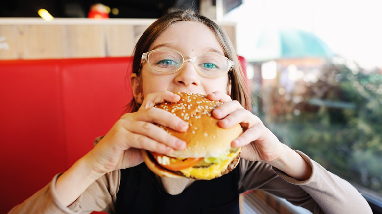 child eating hamburger