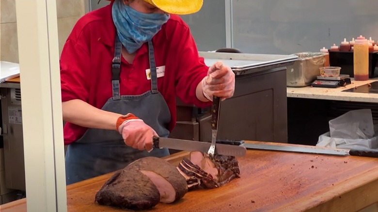 Buc-ee's employee slicing barbecue meat
